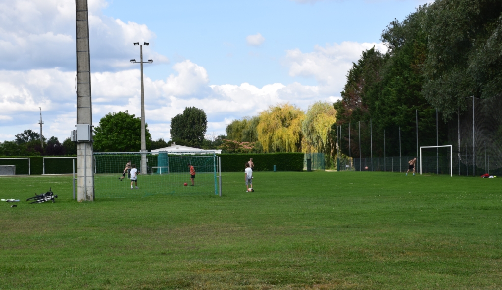 Terrain annexe de la moutte en herbe avec un match entre adolescents en cours