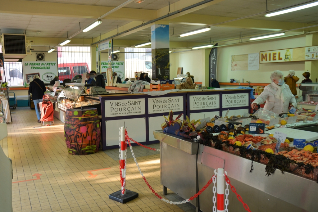 Intérieur du marché couvert avec une vue des commerçant notamment les vignerons