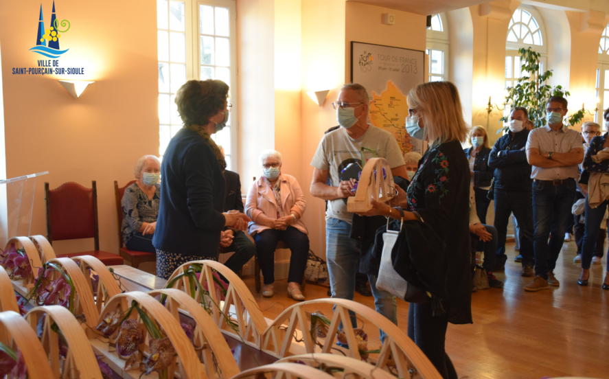 Remise du trophée à des habitants dans la salle d'honneur par une adjointe au maire