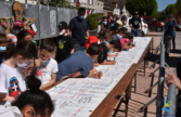 Les enfants élaborent une banderole avec des dessins pour sensibiliser la population à la pollution en ville