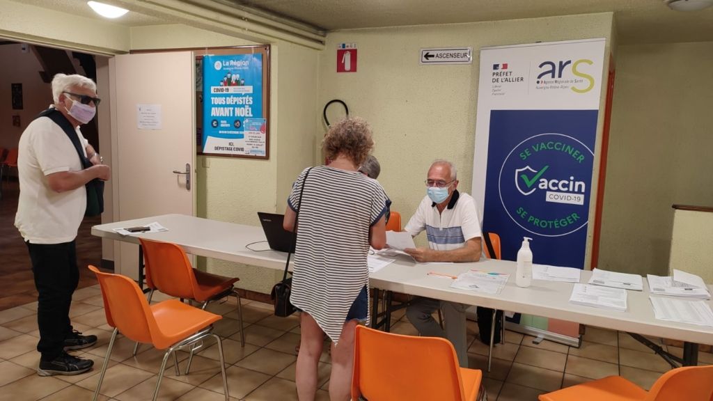 Entrée du centre de vaccination avec des bénévoles et des patients
