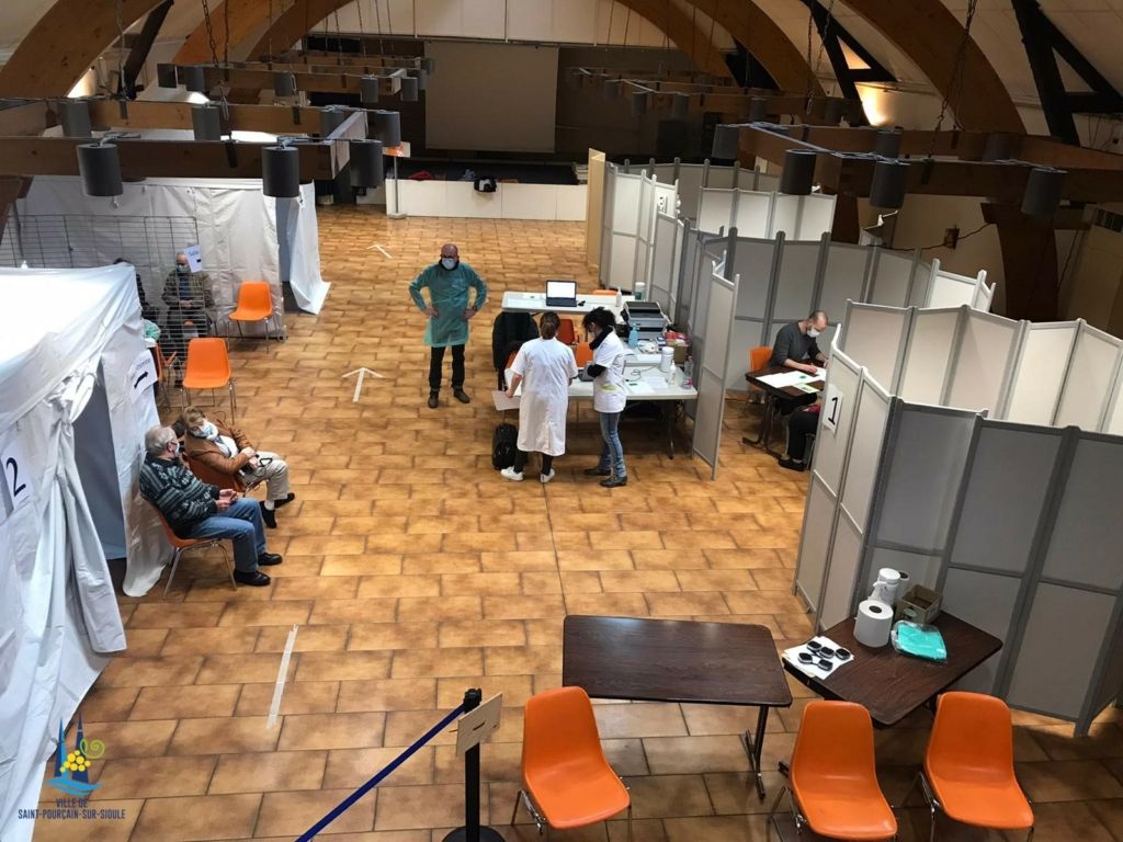 Vue du centre de vaccination avec personnel de santé et bénévole en action