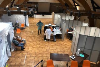 Vue du centre de vaccination avec personnel de santé et bénévole en action